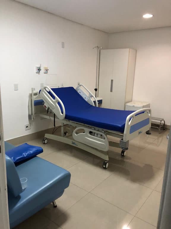 Apartamento de internação com cama eletrônica, poltrona e televisão